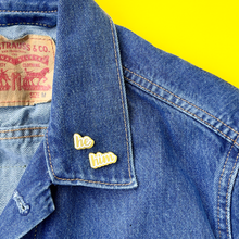 Load image into Gallery viewer, He/Him matte gold and white pronoun pins on jean jacket by proud zebra