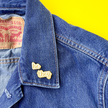 Load image into Gallery viewer, He/They matte gold and white pronoun pins on jean jacket by proud zebra
