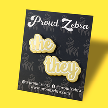 Load image into Gallery viewer, She/They matte gold and white pronoun pins on black backing card by proud zebra