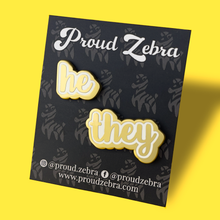 Load image into Gallery viewer, He/They matte gold and white pronoun pins on black backing card by proud zebra
