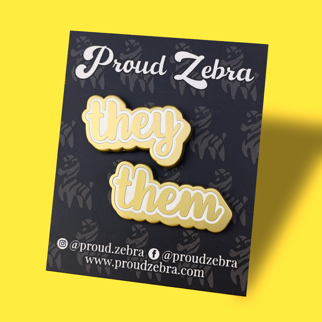They/Them matte gold and white pronoun pins on black backing card by proud zebra